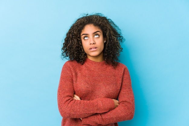 Jeune femme aux cheveux bouclés afro-américaine fatiguée d'une tâche répétitive.