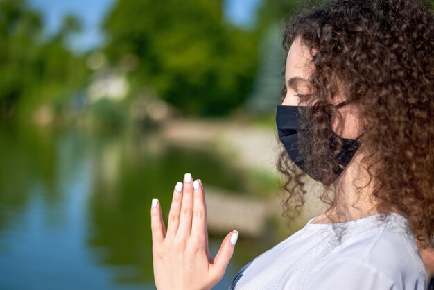 Photo une jeune femme aux cheveux bouclés, faire du yoga à l'extérieur