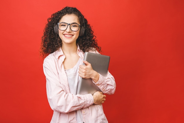 Jeune femme aux cheveux bruns bouclés avec ordinateur portable