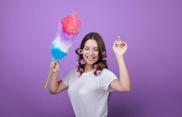 Jeune femme aux cheveux bruns s'amuser pendant le nettoyage.