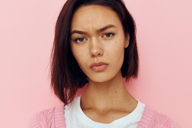 Jeune femme aux cheveux courts et un pull rose fond isolé