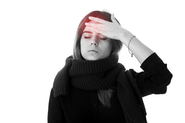 Jeune femme aux cheveux noirs en chemisier noir avec foulard ayant mal à la tête sur fond blanc en studio