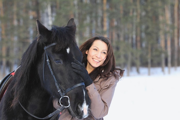 Jeune femme aux cheveux noirs avec un cheval