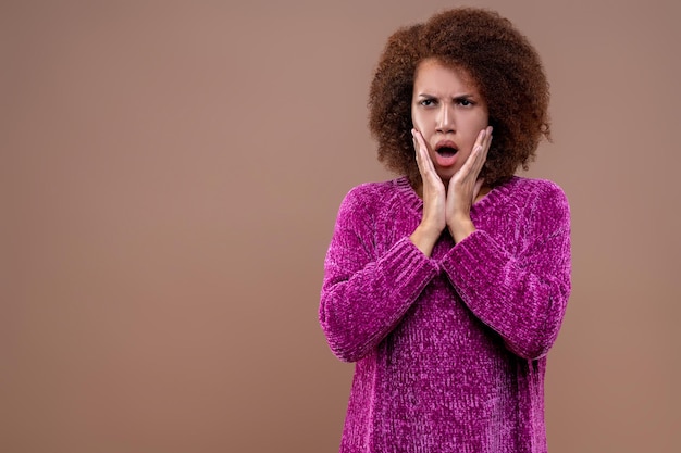 Une jeune femme aux cheveux noirs qui a l'air choquée et stressée