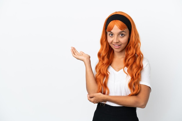 Jeune femme aux cheveux orange isolé sur fond blanc étendant les mains sur le côté pour inviter à venir