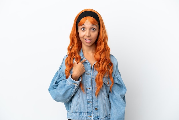 Jeune femme aux cheveux orange isolé sur fond blanc avec une expression faciale surprise