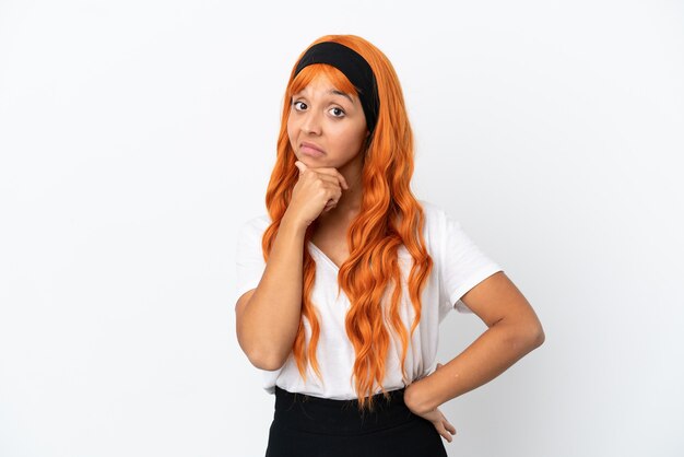 Jeune femme aux cheveux orange isolé sur fond blanc pensant