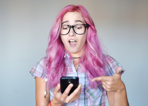 Jeune femme aux cheveux roses avec smartphone