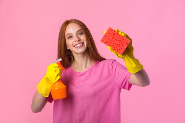 Jeune femme aux cheveux rouges dans des gants en caoutchouc jaune