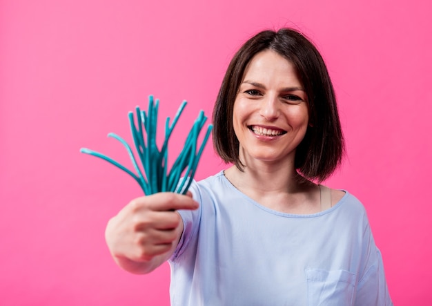 Jeune femme aux dents sensibles mangeant des bonbons sucrés sur fond de couleur