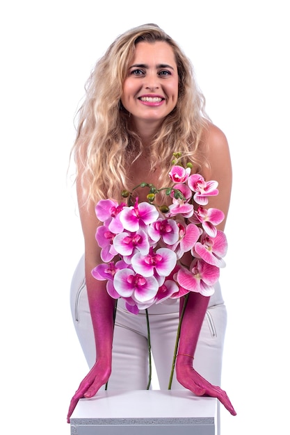 Jeune femme aux mains roses et fleurs sur fond blanc.