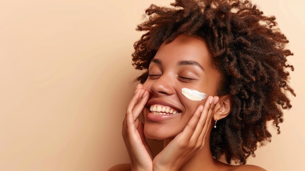 Une jeune femme aux taches de rousseur s'applique une crème blanche sur le visage sur un fond neutre