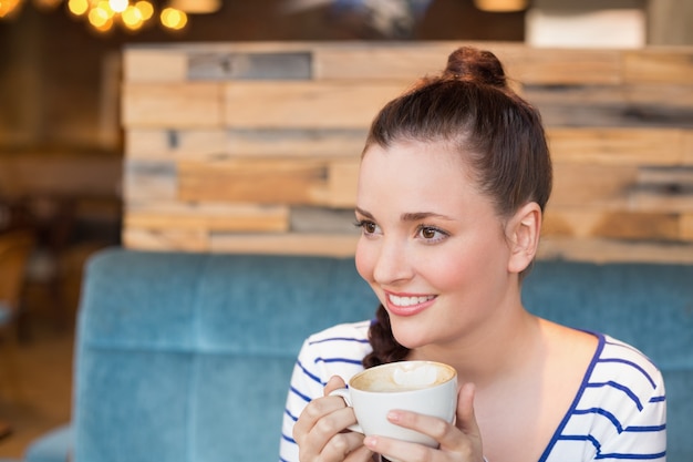 Jeune femme ayant un cappuccino