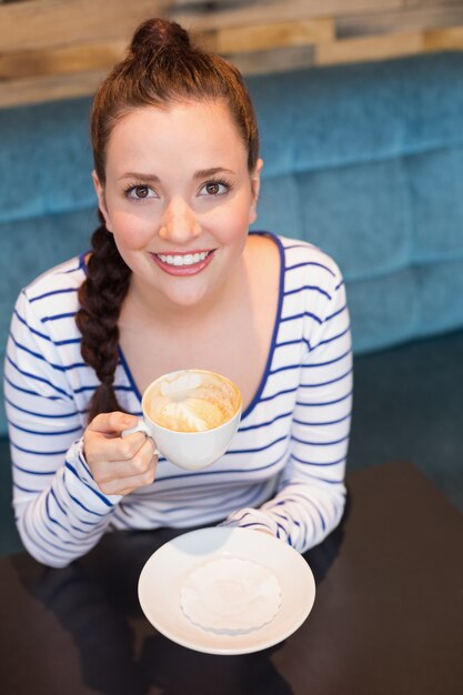 Jeune femme ayant un cappuccino