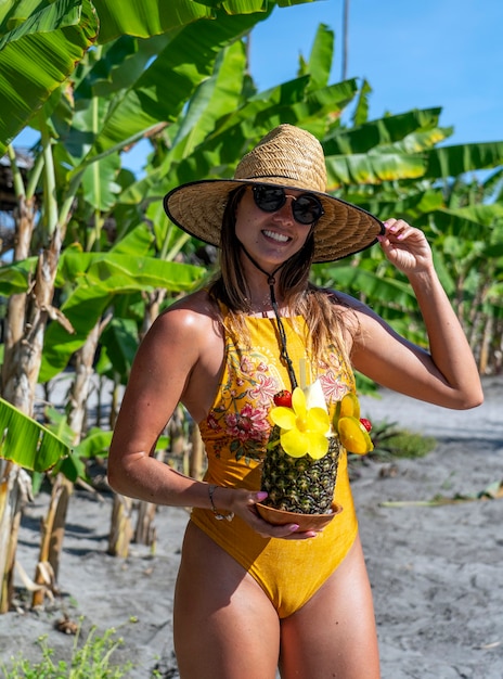 Jeune femme ayant un cocktail à l'ananas sur les plages du nord-est du Brésil