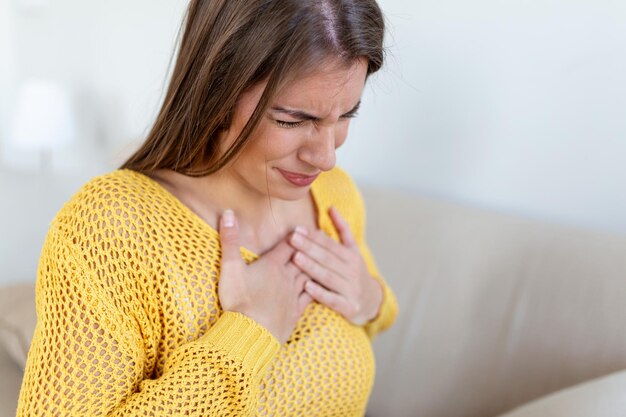 Jeune femme ayant des douleurs à la poitrine Douleur aiguë possible crise cardiaque Effet du stress et du concept de mode de vie malsain