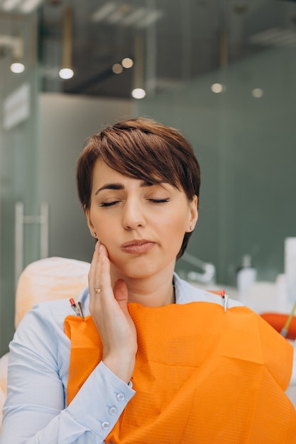 Jeune femme ayant mal aux dents et en attente de dentiste