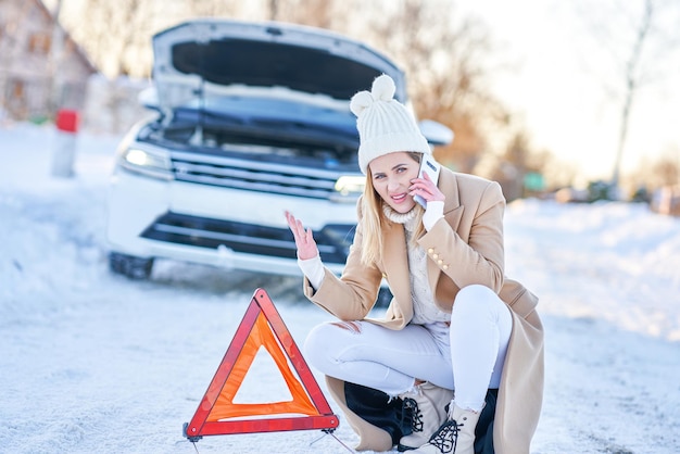 Jeune femme ayant un problème avec la voiture en hiver. photo de haute qualité