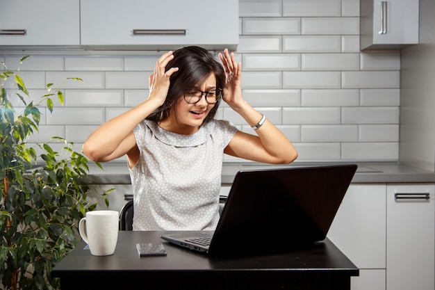 Jeune femme ayant des problèmes avec un ordinateur portable