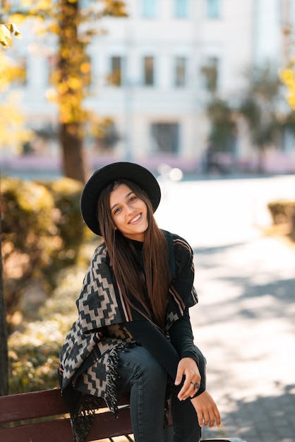 Jeune femme sur un banc dans le parc en automne