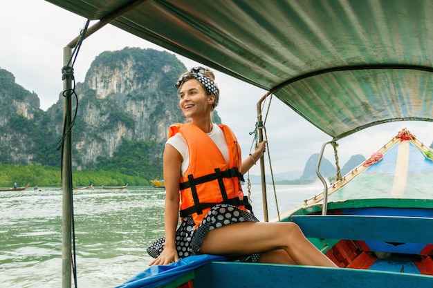 Jeune femme sur le bateau à longue queue pendant ses vacances en Thaïlande