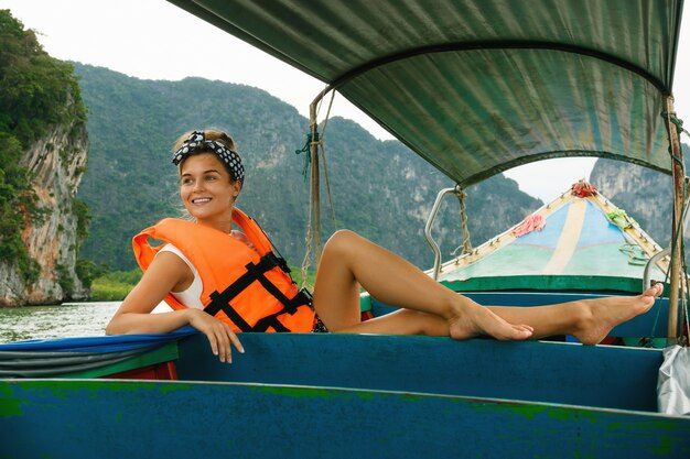 Jeune femme sur le bateau à longue queue pendant ses vacances en Thaïlande