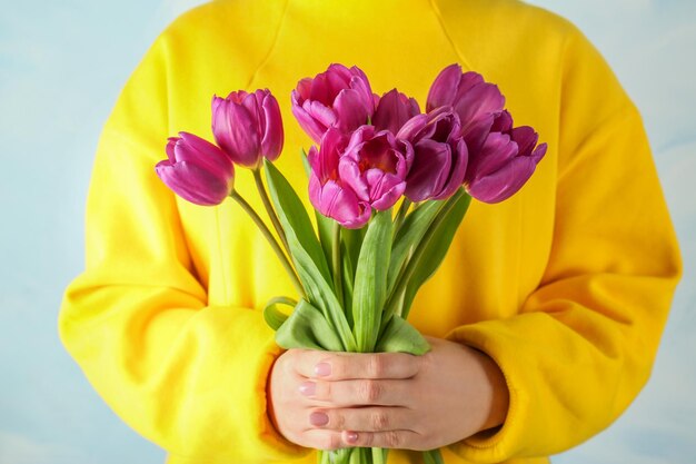 Jeune femme avec un beau bouquet de tulipes lilas agrandi