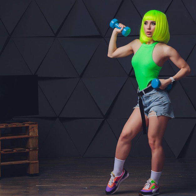 Jeune femme avec un beau corps mince et sain qui pose en studio Modèle féminin de remise en forme en vêtements de sport sur fond gris