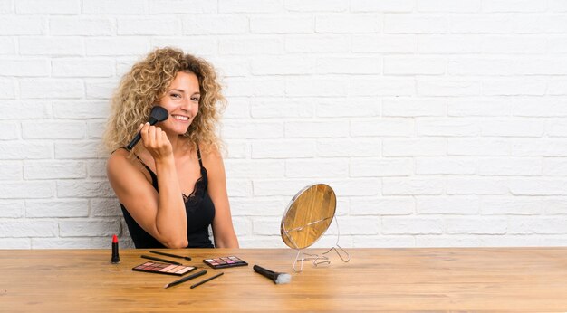 Photo jeune femme avec beaucoup de pinceau de maquillage dans une table