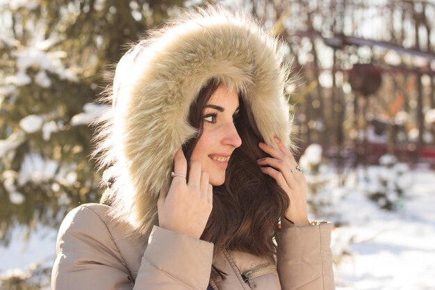 Jeune femme de beauté dans le parc d'hiver en journée froide d'hiver