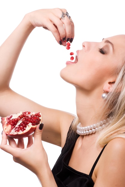 Photo jeune femme de beauté avec la grenade rouge fraîche