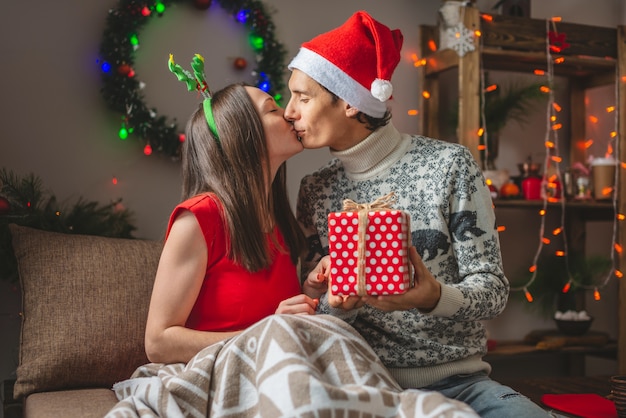 Jeune femme belle femme donne à son mari une boîte cadeau surprise