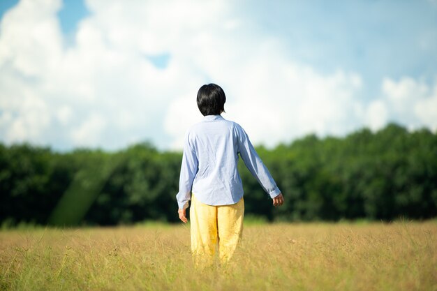 Jeune femme belle femme heureuse à la belle prairie au fond de ciel. notion de bonheur.