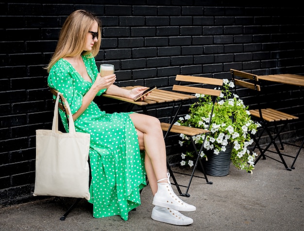 Jeune femme belle avec un sac écologique en lin sur fond de ville