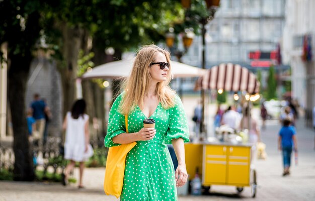 Jeune femme belle avec un sac écologique en lin jaune sur fond de ville