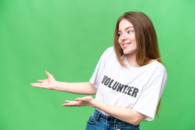 Jeune femme bénévole sur fond isolé chroma key avec une expression surprise tout en regardant de côté