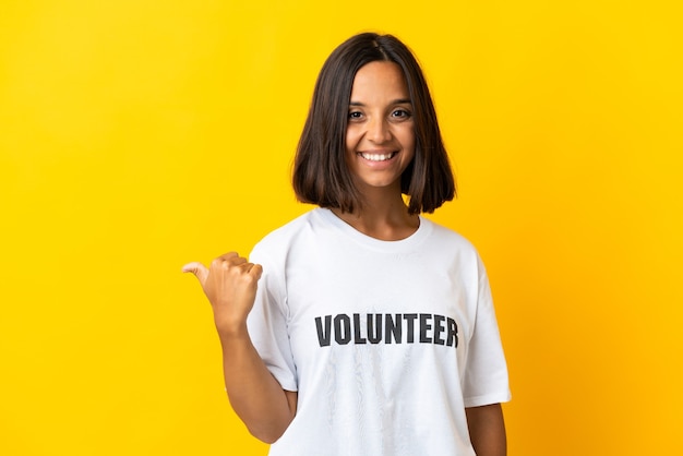 Jeune femme bénévole isolée pointant vers le côté pour présenter un produit