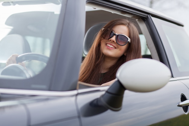 Jeune femme beuatiful au volant d'une voiture