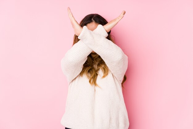 Jeune femme bien roulée posant en gardant deux bras croisés, concept de déni.