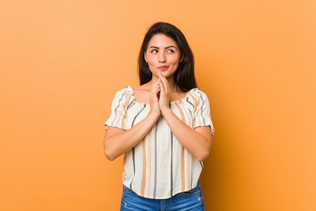 Jeune femme bien roulée qui invente un plan, qui met en place une idée.