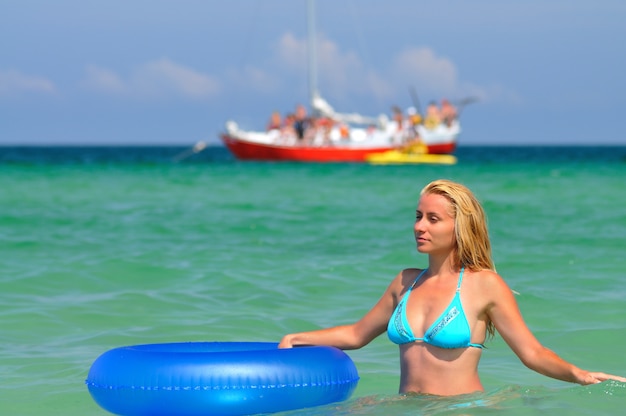 Jeune femme en bikini bleu avec un cercle de natation