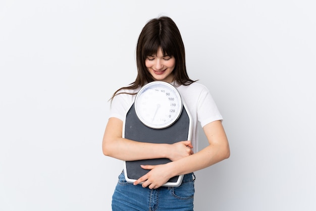 Jeune femme sur blanc isolé avec peseuse