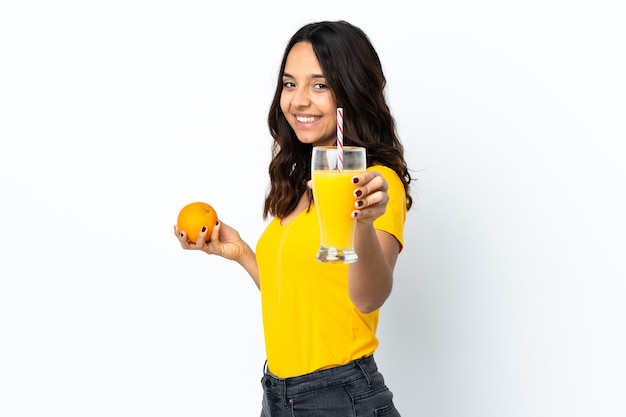 Jeune femme sur blanc isolé tenant une orange et un jus d'orange