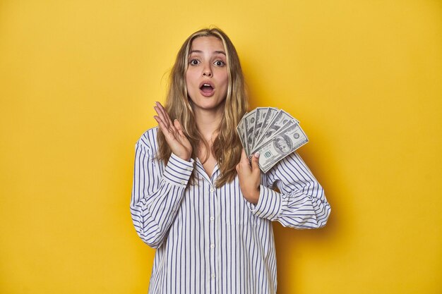 Photo une jeune femme blanche avec de l'argent surprise et choquée