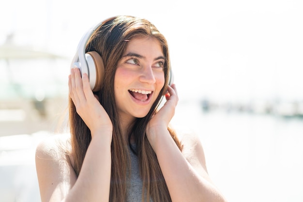 Une jeune femme blanche écoute de la musique et chante.