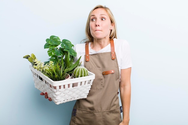 Jeune femme blonde adulte jardiner avec des plantes