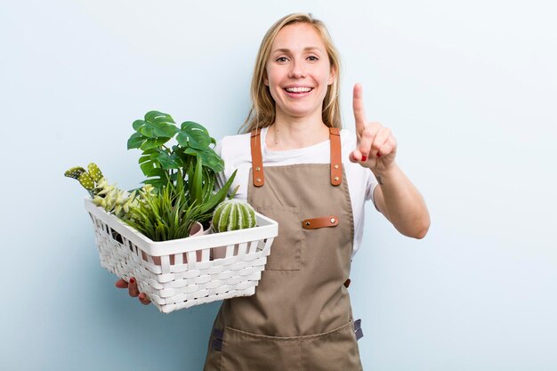 Jeune femme blonde adulte jardiner avec des plantes