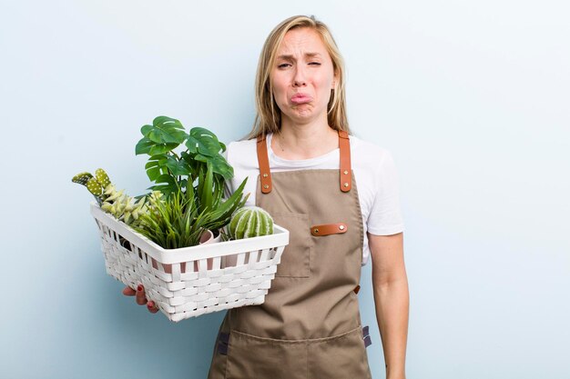 Jeune femme blonde adulte jardiner avec des plantes