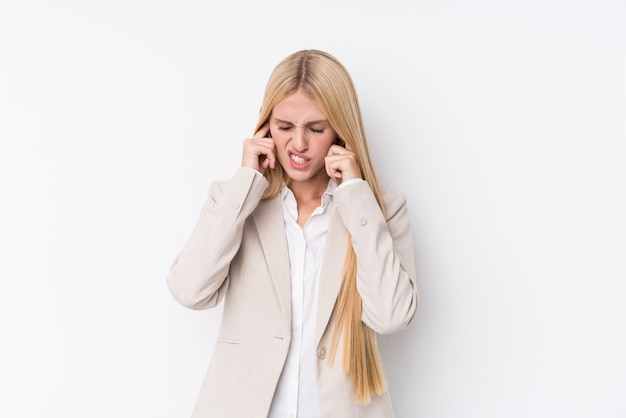 Jeune femme blonde d'affaires couvrant les oreilles avec les mains