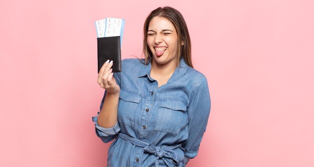 Jeune femme blonde avec une attitude joyeuse, insouciante et rebelle, plaisantant et collant la langue, s'amusant